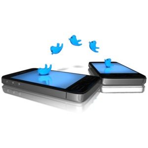 two cell phones lay down with twitter birds moving from one phone to the other